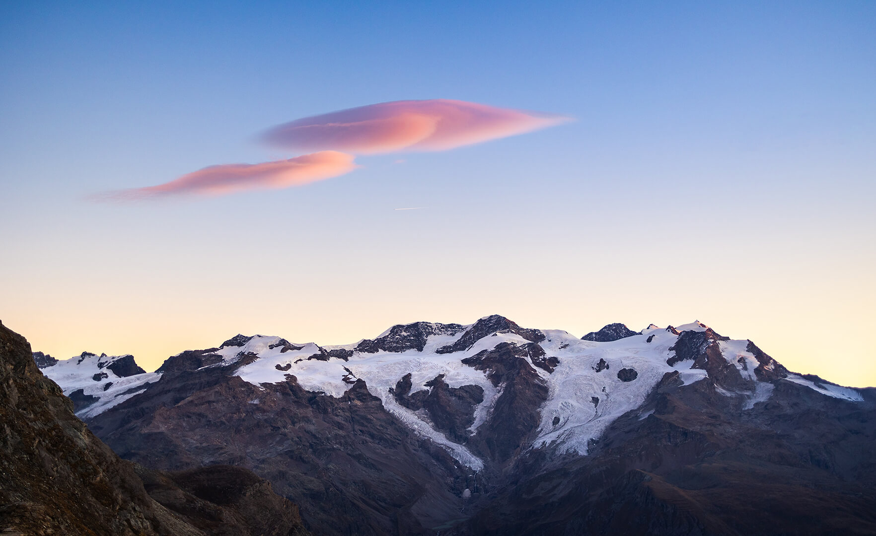Background image of a sunset over a mountain range covered in snow